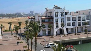 Un hôtel situé sur la côte, doté d’un design moderne, de plusieurs étages et de balcons.