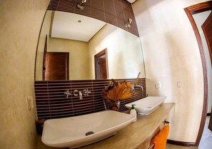 Ein Badezimmer mit zwei Waschbecken, einem großen Spiegel und einem Handtuchhalter.