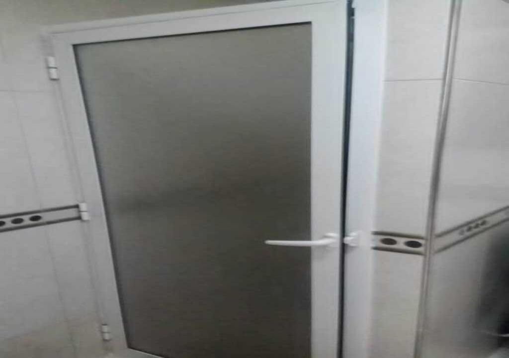 A closed door with a handle, a white frame, and a glass panel.