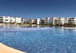 A swimming pool with a clear blue water surface, surrounded by modern buildings. - Residence Playa Del Pacha 4950 (Mdiq)