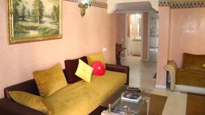 Uma sala de estar com um sofá, uma mesa de centro e um quadro na parede.