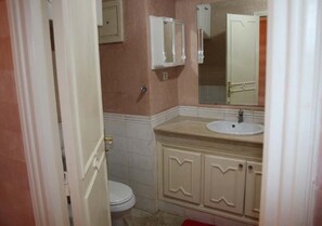 A bathroom with a toilet, a sink, and a mirror. - Residence Atlas Hivernage 4971 (Marrakech)
