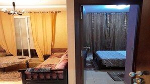 A room with a bed, a sofa, a curtain, and a door. - Holiday residence Islane Agadir 4981 (Agadir)
