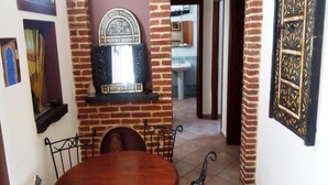 Un comedor con pared de ladrillo, un espejo decorativo y suelo de baldosas.