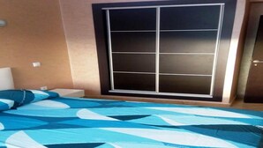 A bedroom with a bed, a large window with a sliding door, and a wall-mounted shelf. - Residence Riviera Beach 5017 (Cabo Negro)