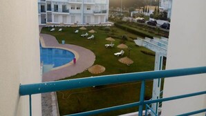 A view of a hotel courtyard with a swimming pool, lounge chairs, and umbrellas. - Residence Riviera Beach 5017 (Cabo Negro)