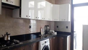 Een moderne keuken met roestvrijstalen apparatuur, witte kasten en een ingebouwde wasmachine.