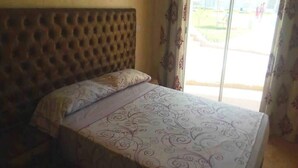 A bed with a patterned bedspread and a tufted headboard. - Residence Riviera Beach 5024 (Cabo Negro)