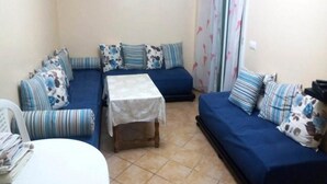 A compact living room with two blue sofas, a small white table, and striped cushions. - Residence Riviera Beach 5024 (Cabo Negro)