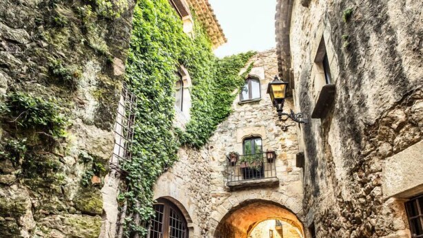A narrow stone alley with arched doorways, ivy-covered walls, and a cobblestone path. - Can Berta by Interhome (Pals)
