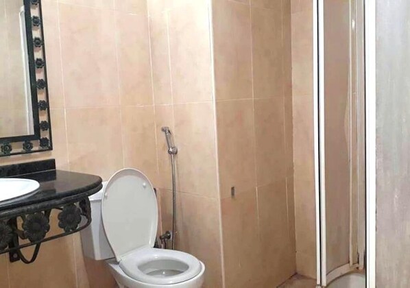 A bathroom with a toilet, a sink, and a shower.