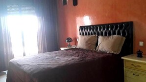 Une chambre à coucher avec un grand lit, une table de chevet et une commode.