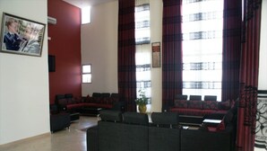 A modern living room with a sectional sofa, a small table, and a potted plant. - Residence Appart Hotel Founty Beach 5123 (Agadir)
