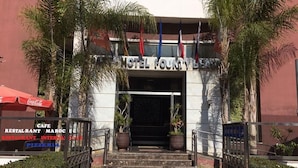 The entrance to Hotel Founty Beach with steps leading up to the door, surrounded by palm trees and potted plants. - Residence Appart Hotel Founty Beach 5142 (Agadir)