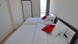 A hotel room with two beds, a wardrobe, and a window with curtains. - Residence Appart Hotel Founty Beach 5142 (Agadir)