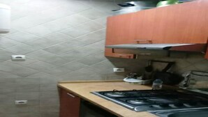 Una cucina con piano cottura a gas, forno e schienale piastrellato.