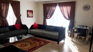 Una sala de estar con dos sofás, una mesa de centro y un comedor con sillas.
