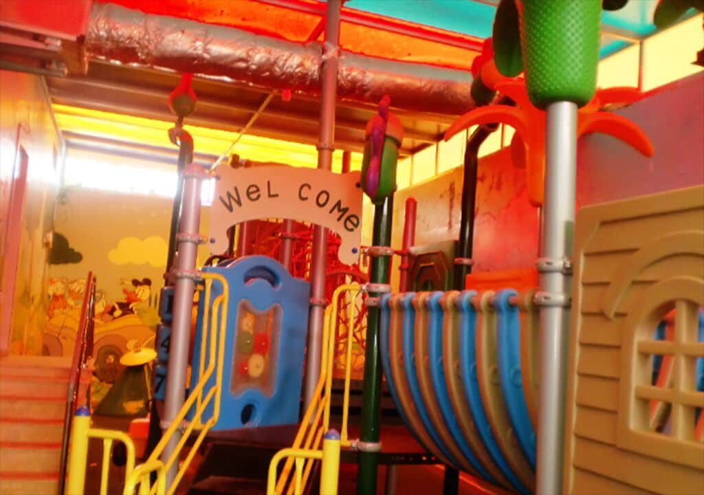Un espace de jeux coloré avec une pancarte sur laquelle on peut lire : « Bienvenue ».