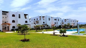 Un edificio blanco con varios balcones y una piscina.