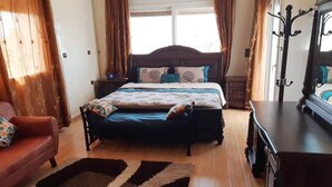 A bedroom with a bed, a nightstand, a dresser, and a mirror. - Large Beachfront Villa in Sonaba Agadir 5164 (Agadir)
