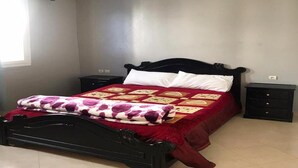 Un dormitorio con una cama, dos mesitas de noche y una ventana.