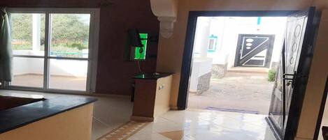 A reception area with a counter, a green screen, and a door leading outside.