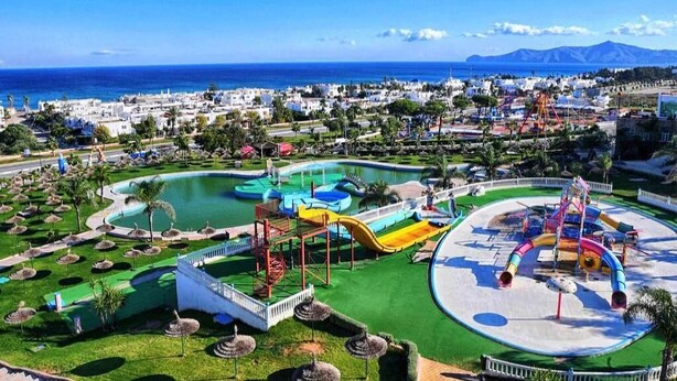 Ein Resort mit großem Pool, Wasserrutschen und Blick aufs Meer.