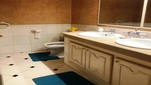 Ein Badezimmer mit zwei Waschbecken, einer Toilette und einem großen Spiegel.