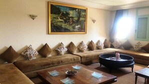 Ein Wohnzimmer mit einer Sofagarnitur, einem Couchtisch und einem Bild an der Wand.