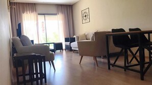 Una sala de estar con sofá, sillones, una mesa baja y una mesa de comedor.