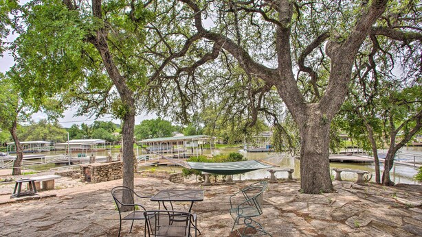 A park with stone flooring, metal chairs, a table, and a hammock. - Possum Kingdom Lakefront Home w/ Patio & Dock! (Graford)