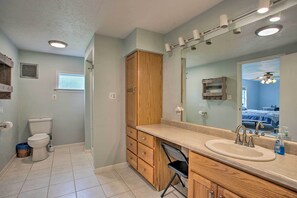 Une salle de bain avec des toilettes, des meubles en bois, un lavabo et un miroir.