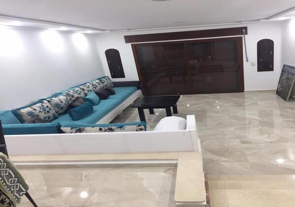 A living room with a sofa, a coffee table, and a sliding door.