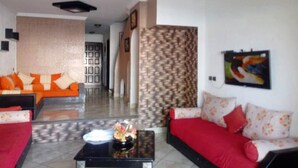 A living room with a sofa set, a coffee table, and a patterned wall.