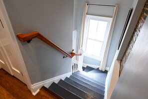 Eine Treppe mit hölzernen Handläufen und einer weißen Tür am oberen Ende.