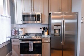 A modern kitchen with stainless steel appliances, including a microwave, oven, and refrigerator.
