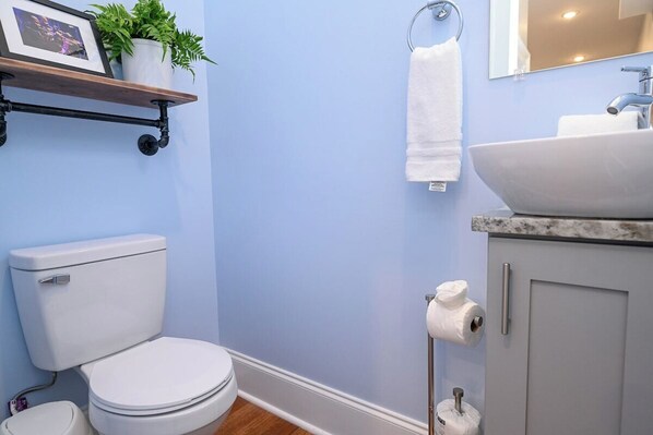 Un baño con inodoro, lavamanos y toallero.