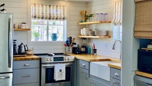 A modern kitchen with stainless steel appliances, wooden countertops, and a window with a view of greenery. - Hooked on Bayou? Waterfront! Kayaks, Fishing, Dock, The Views! (Carrabelle)