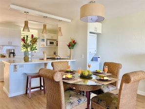 Enjoy meals in the well-appointed kitchen and dining area, featuring a central island, stainless steel appliances, and a round dining table.