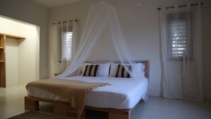 A bedroom with a wooden bed, white bedding, and a canopy. - VillaMerissa Nestled between two unspoiled beaches Pool/JackSprat/WiFi/Gym/Staff (Treasure Beach)