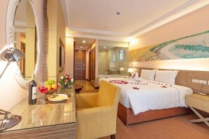 A hotel room with a bed, a desk with a lamp, a chair, and a large mirror. - Vietsovpetro Dalat Hotel (Xuan Huong - Da Lat)