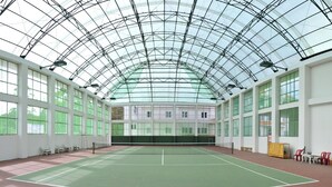 An indoor tennis court with a glass ceiling, large windows, and seating areas. - Vietsovpetro Dalat Hotel (Da Lat)