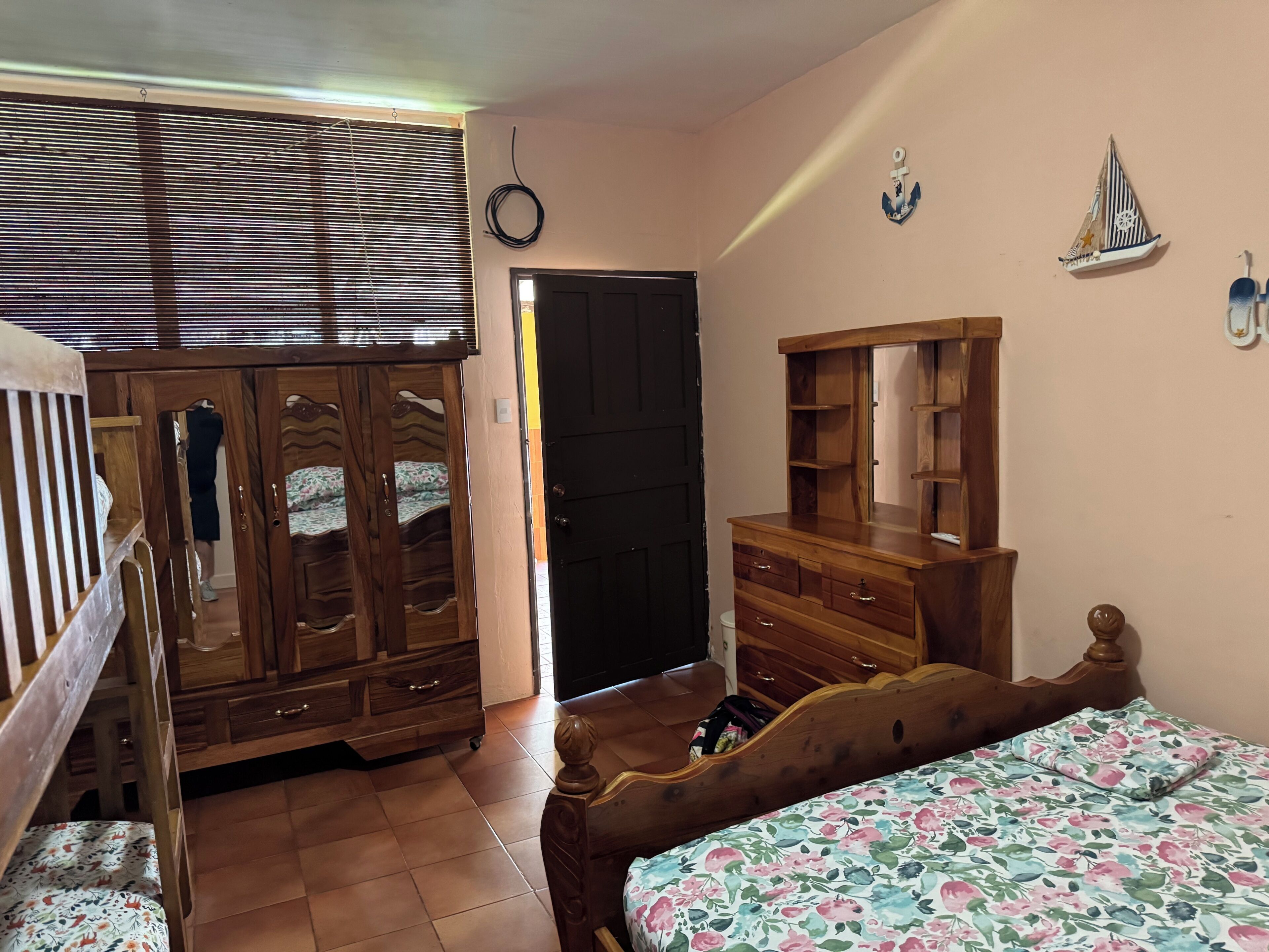 Une chambre à coucher avec un lit en bois, une armoire, une commode et un miroir.