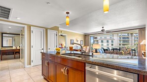 A modern kitchen with a stainless steel dishwasher, wooden cabinets, and a large island with a sink.