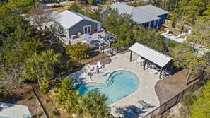A residential property with a swimming pool, a covered patio, and a deck area.