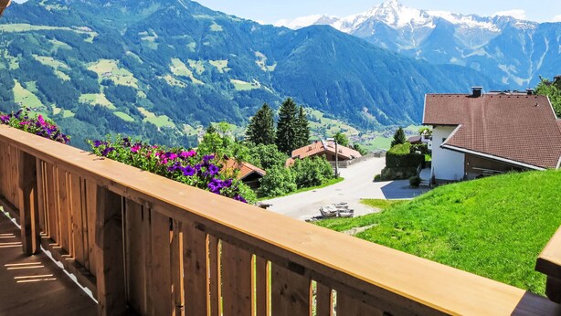 A balcony with a wooden railing overlooking a mountainous landscape with houses and a clear sky. - Apartment Dengg by Interhome (Hippach)