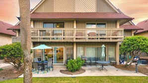 A two-story building with a balcony, outdoor seating area, and a small garden. - Pool + Ocean View + Walk to Beach - Villa (Fripp Island)