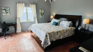 A bedroom with a bed, a desk, and a window with curtains. - Stunning Paradise Overlook - Incredible Views from Every Room (Christiansted)