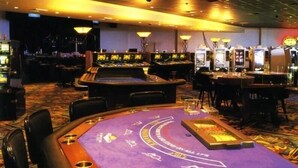 A casino floor with multiple gaming tables, slot machines, and a large roulette wheel. - Stunning Paradise Overlook - Incredible Views from Every Room (Christiansted)