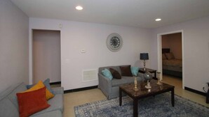 Una sala de estar con un sofá gris, una mesa de centro y un tapete azul estampado.